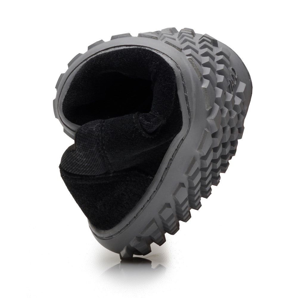 A ZAQQ SHOQQ Black egy fekete csizma vastag, robusztus talppal, geometrikus profilmintával fehér háttéren, hogy kiemelje robusztus dizájnját. Ez a sokoldalú vegán barefoot cipő ideális azok számára, akik kültéri kalandjaik során tartósságot és barefoot érzést keresnek.