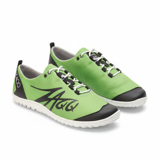 Grüne SQIM-Sportschuhe aus veganen Materialien mit weißer Sohle und schwarzen Akzenten. Diese ZAQQ-Sneaker haben schwarze Schnürsenkel und ein stilisiertes Design an der Seite, wobei der Markenname auf der Fersenlasche abgebildet ist.