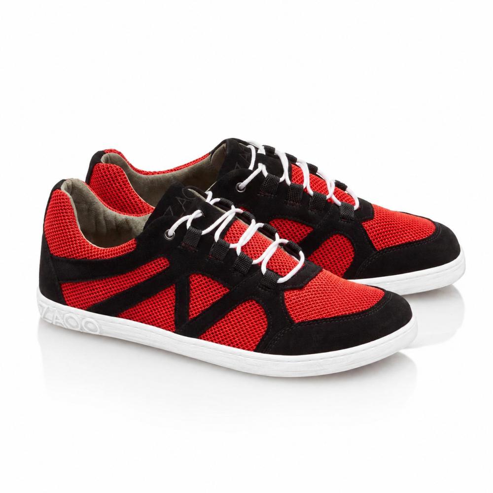 Egy pár QUSQO Red-Sneaker a ZAQQ-tól, amely piros hálós betéteket és fekete velúr részleteket kombinál, fehér cipőfűzőkkel és fehér talppal kiegészítve. Ezek a futócipők egyedi hullámos varrási mintával rendelkeznek az oldalán, és a márkanevet elegánsan a sarokra helyezték.
