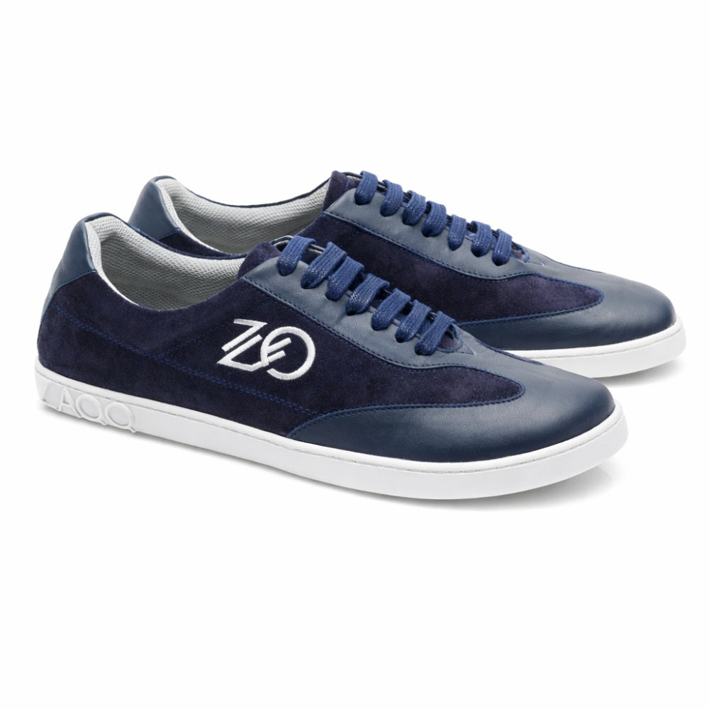 A Queensburry Marine ZAQQ egy tengerészkék színű, vadbőr és sötétkék bőr anyagból készült mezítlábas sneaker, amelyet az oldalán elegáns fehér hímzés díszít. Ezek a cipők fehér talpukkal és hozzáillő kék cipőfűzőikkel kényelmet biztosítanak járás közben.