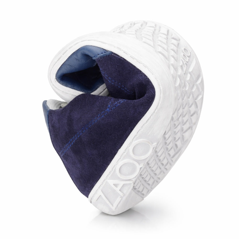 A ZAQQ Queensburry Marine mezítlábas sneaker rugalmas kialakítással rendelkezik, fehér talppal és sötétkék bőr felsőrésszel, amely fokozott kényelmet biztosít járás közben. Hajlékony szerkezete, strukturált profiljai a talpon, és az oldalra nyomott 400-as szám jellemzik.